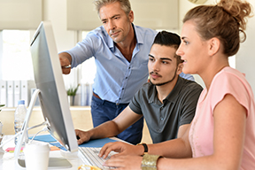 Photo of a banking professional and two interns. Photo of a banking professional and two interns.